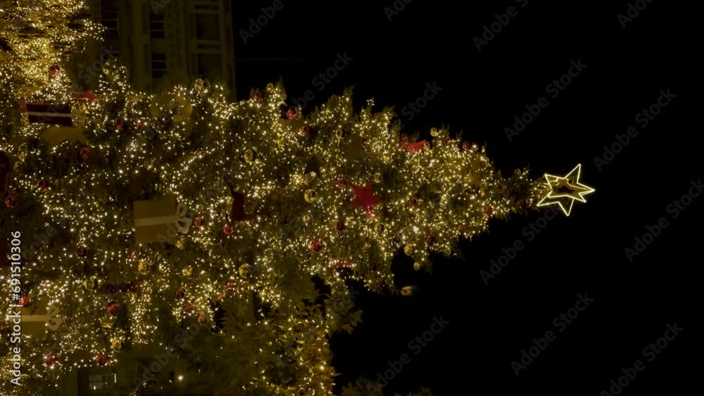 Christmas tree and lights at night in decorated and illuminated central square Syntagma in Athens, Greece. Winter holidays background. Vertical orientation