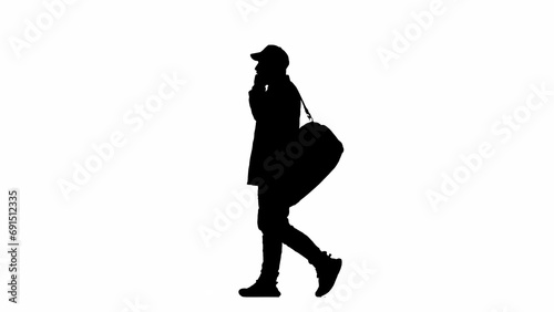 Portrait of traveler isolated on white background alpha channel. Silhouette of man cap walking with sport bag and talking on smartphone.