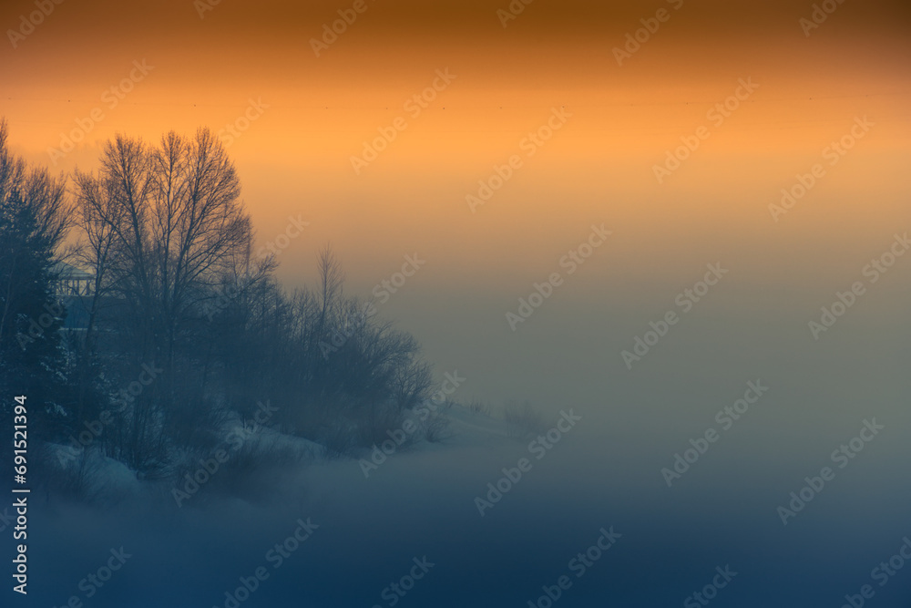 Forest and river in winter covered by snow. Winter morning in the fog. Forest and river in winter covered by snow. Winter morning in the fog.