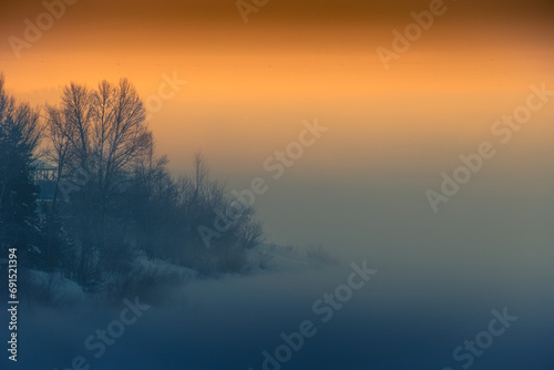 Fototapeta Naklejka Na Ścianę i Meble -  Forest and river in winter covered by snow. Winter morning in the fog.
