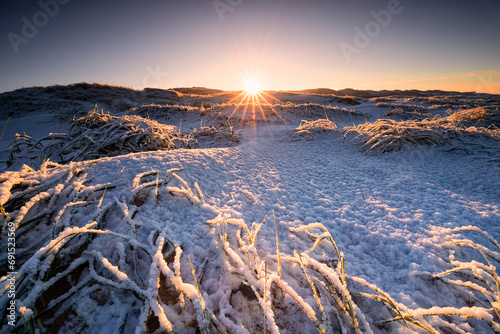 sunrise oer snowy dunes on sea coast