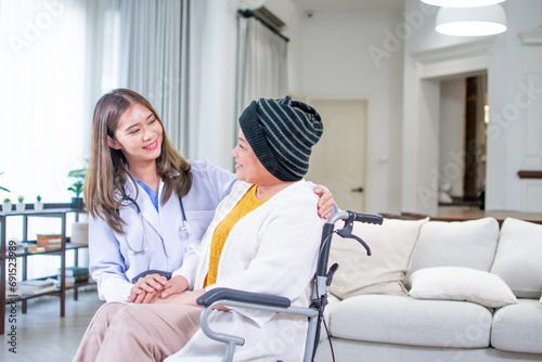 Asian beautiful smart female doctor wearing uniform, talking to cancer aging senior old female patient, sitting at home, smiling with happiness. Healthcare, Insurance, Retirement Concept.