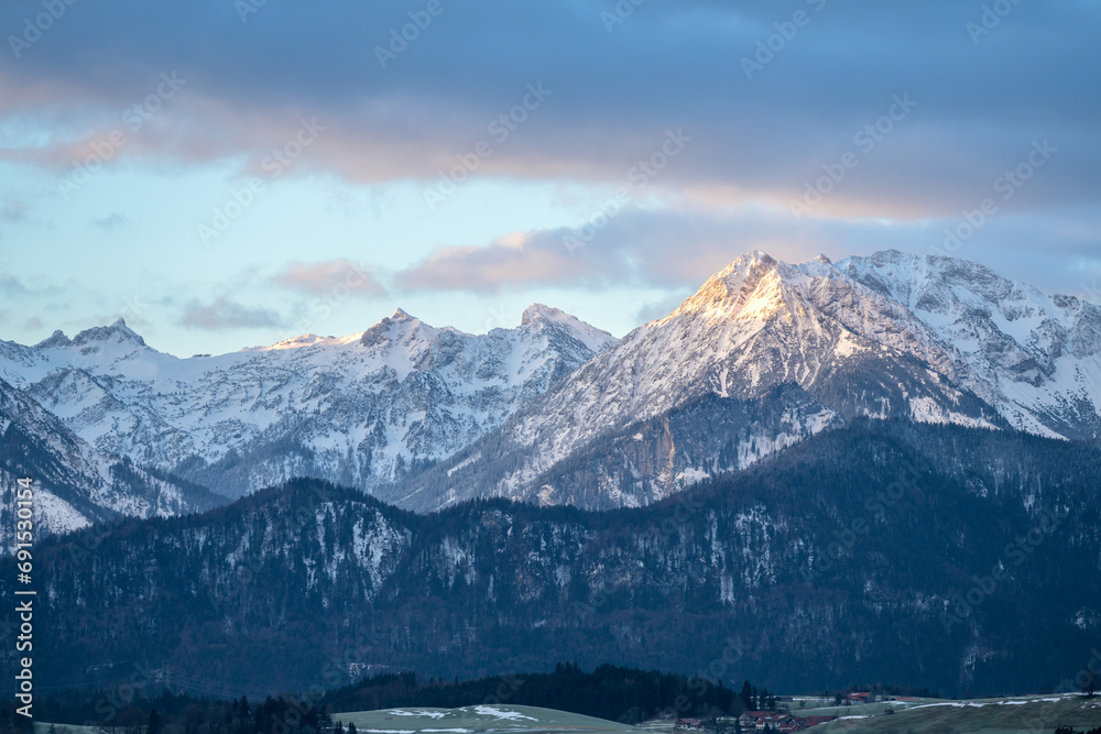 Alpine panorama with snow-covered mountains on a frosty morning at sunrise