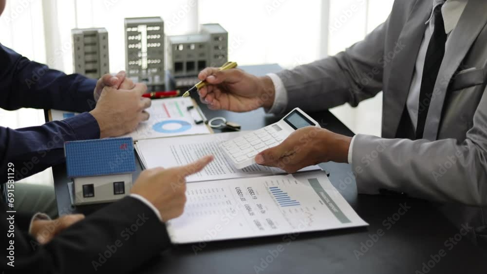 Businessman is negotiating a contract for the purchase and sale of a house. Real estate agent is offering a house for sale and a businessman signs an agreement document. Businessman is negotiating a contract for the purchase and sale of a house. Real estate agent is offering a house for sale and a businessman signs an agreement document.