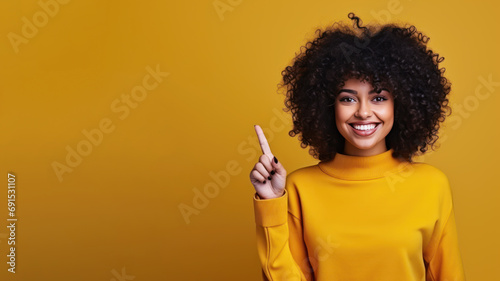 Happy afro woman pointing her finger at copy space for promotion photo