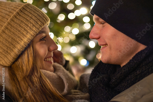 Profile photo of a beautiful young couple in love, enjoying the winter holiday season in the nicely decorated city streets, while celebrating x-mas evening (ID: 691532733)