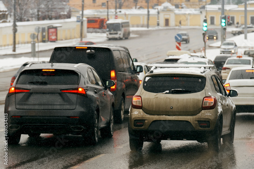 Dirty road due to reagents. Dirty cars drive along a winter highway, snow melts on a city road.