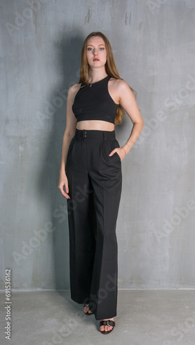 Obraz na płótnie Young beautiful woman, fashion model, in a black suit in the studio w salonie