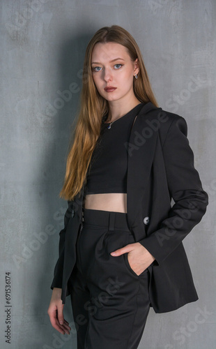 Obraz na płótnie Young beautiful woman, fashion model, in a black suit in the studio w salonie
