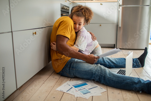 Daughter hugging father during financial bill crisis debt at home photo