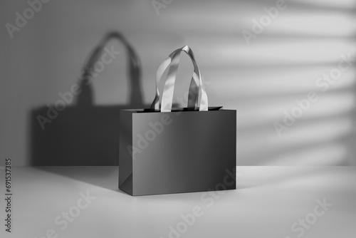 Black paper glossy shopping bag mockup with white handles.
