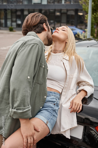 man in stylish casual clothes and sunglasses seducing sensual blonde woman near car on street © LIGHTFIELD STUDIOS