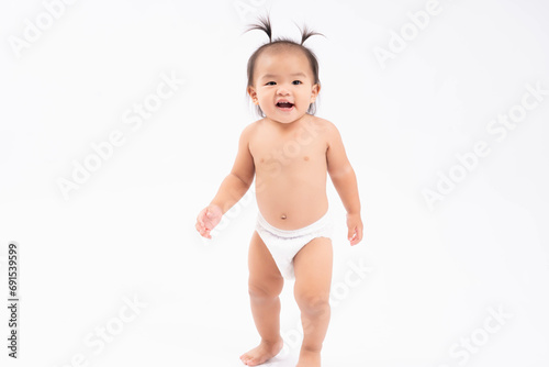 Happy Smiling asian toddler practice walk stand over isolated on white background Baby girl wear diapers It is her first step Toddler girl get funny hairdo Advertising template for children's product  photo