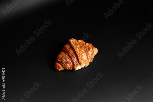 Croissant on black background.