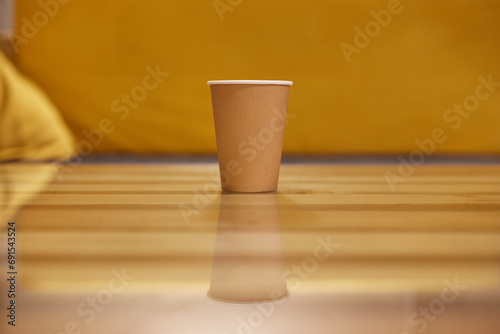 Mockup of Coffee paper cup on glass table with yellow background. © Лев Малевич