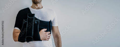 Shoulder orthosis orthoses orthopedic medical recovery sling for support hand background.  photo