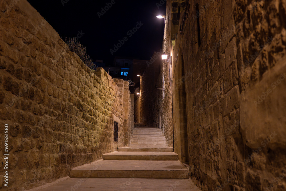 Night view of narrow stone streets in Mardin city center.