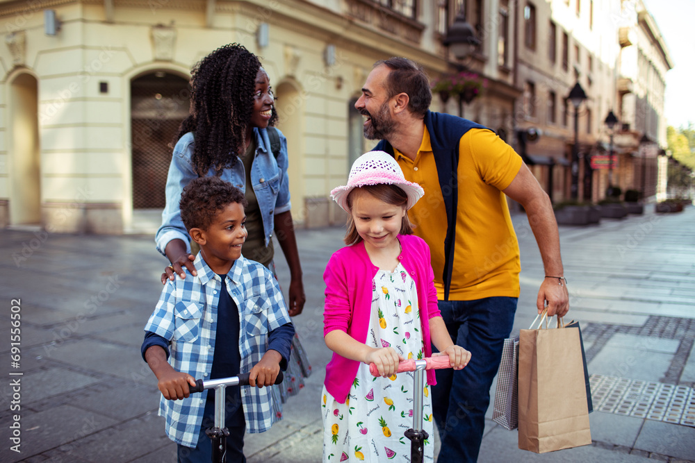 Multiracial couple walking with mixed children in city