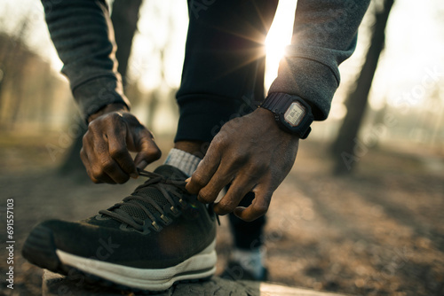 Man tying fitness shoes for outdoor run in park
