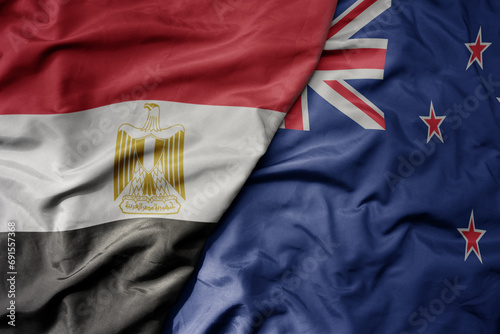 big waving national colorful flag of new zealand and national flag of egypt .