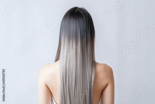 The young lady's back, her long silver hair flowing smoothly against the white studio background, showcasing her elegant and chic style. Generative AI.