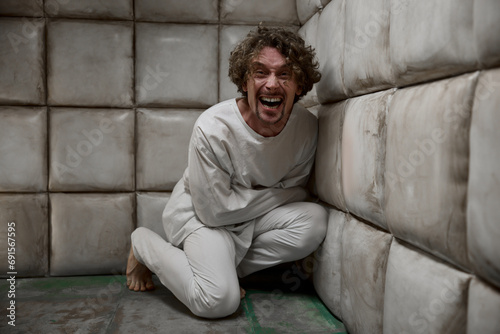 Obraz na płótnie Mad crazy man patient wearing straitjacket laughing terrifying w salonie