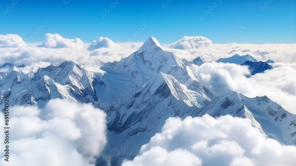 Snow peaks high above the clouds with a blue sky