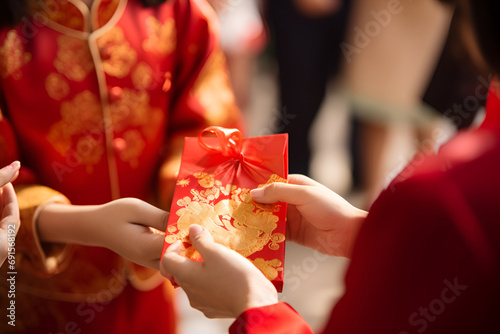 A woman presents a red hongbao envelope with a gold pattern, Chinese tradition photo