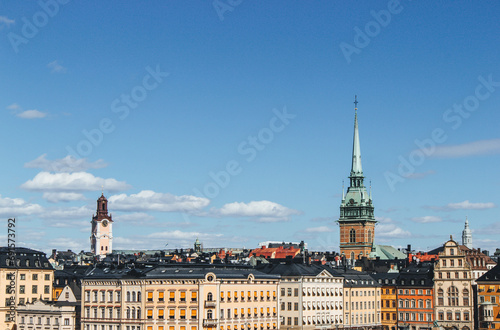 panoramic view of rooftops and view of the town hall tower with many colorful houses in stockholm 