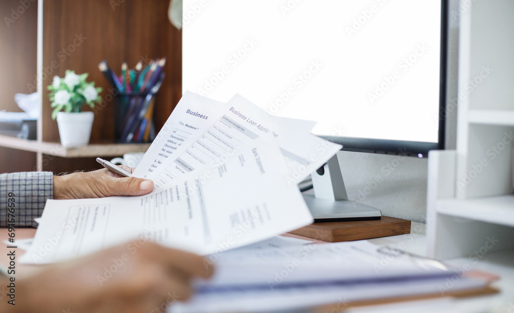 © Lek - Close-up shot, businessman working on desk with business documents and meeting online via computer, online meeting and chat with business group to start new business plan © Lek - Close-up shot, businessman working on desk with business documents and meeting online via computer, online meeting and chat with business group to start new business plan