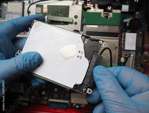 Plakat Technician installing hard disk to computer. Removing or plugging in disk cable. Data recovery concept background.