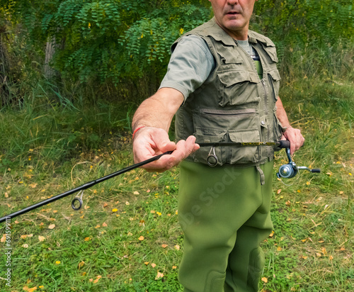 Angler connecting the two parts of his fishing rod