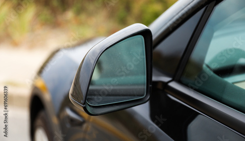 car mirror reflecting cityscape, symbolizing travel, reflection, urban lifestyle, and exploration. Blurred background © Your Hand Please