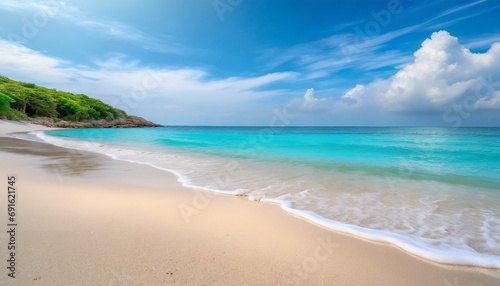 Beautiful sandy beach with white sand and rolling calm wave of turquoise ocean on Sunny day