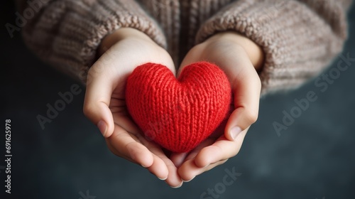 Child hands holding a red heart for share and donate.