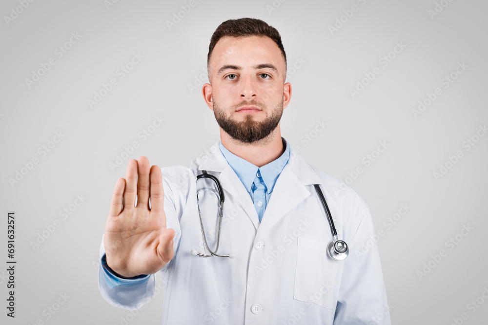 Doctor making stop gesture, signaling caution Doctor making stop gesture, signaling caution
