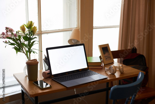 Background image of elegant home office workplace decorated with flowers, laptop screen mock up © Seventyfour