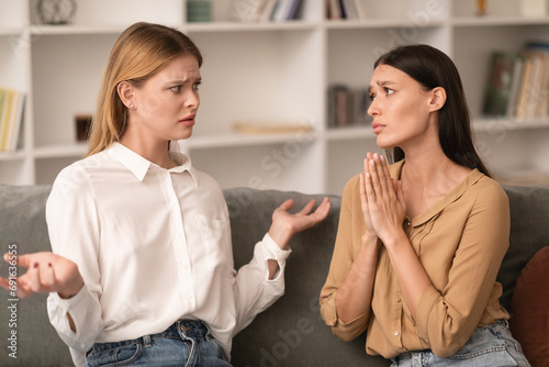 Confused Lady Shrugging Shoulders To Friend Asking For Favor Indoor photo