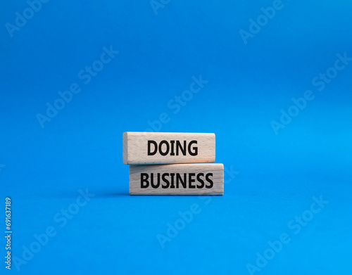 Doing Business symbol. Concept word Doing Business on wooden blocks. Beautiful blue background. Business and Doing Business concept. Copy space