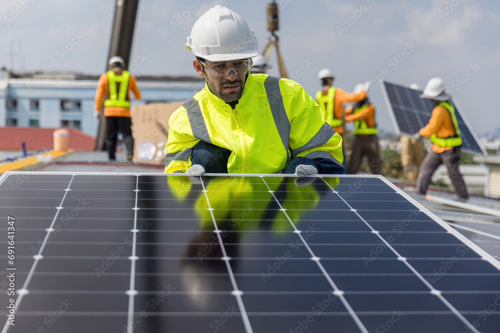Engineer working setup Solar panel at the roof top. Engineer or worker work on solar panels or solar cells on the roof of business building Engineer working setup Solar panel at the roof top. Engineer or worker work on solar panels or solar cells on the roof of business building