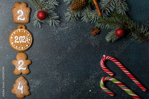 Gingerbread cookies of the form of numbers and 2024. Christmas composition with gingerbread on dark background. Copy space. Flat lay
