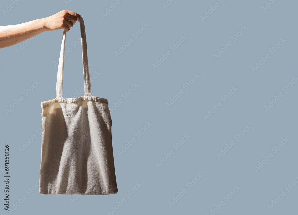 Hand holding tote bag. Natural cotton shopper, banner background Hand holding tote bag. Natural cotton shopper, banner background