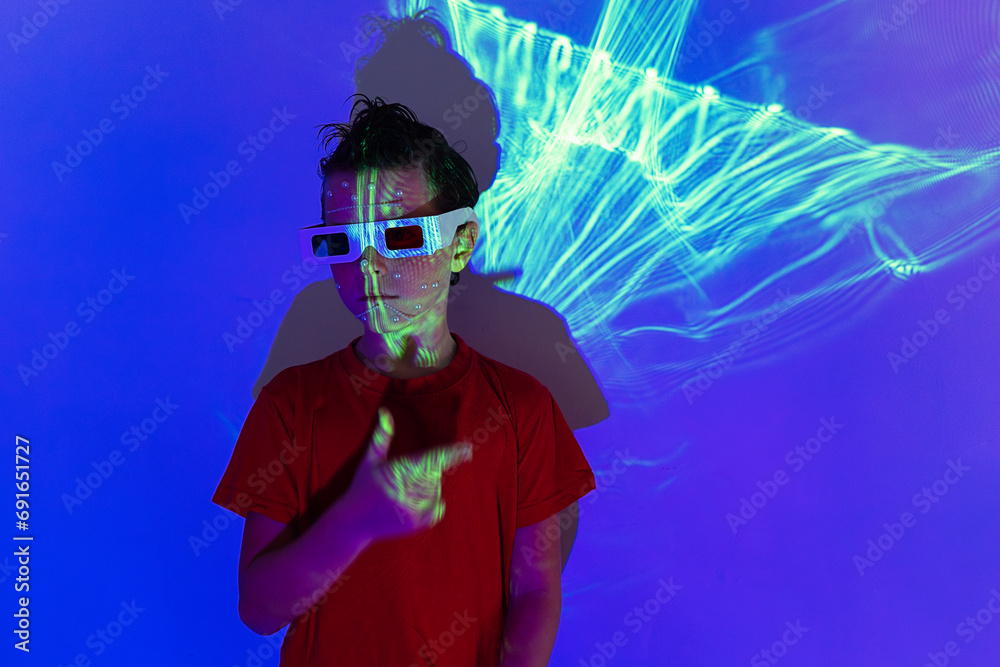 Adorable kid wearing 3D glasses in neon studio with blue lights Adorable kid wearing 3D glasses in neon studio with blue lights
