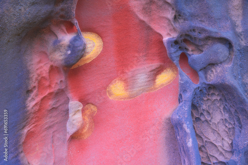 Abstract erosion patterns on multicolored rock surface photo