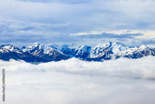 Beautiful view of snow-capped mountains above thick clouds in Bernese Oberland, Switzerland © olyasolodenko