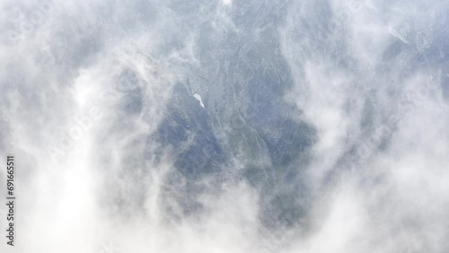 4K aerial footage of misty clouds rising up over Slovakian early morning High Tatras mountain range. Light and shadows playing. Rysy peak 2499m view. photo