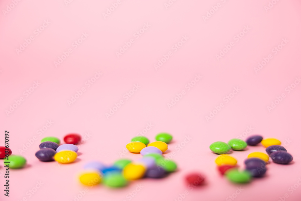 Obraz premium A pink web background with colorful chocolate candies perfect for a party, birthday or Valentines's day