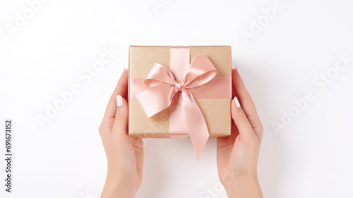 overview of hands holding present with bow over white background © Carlos