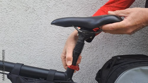 Close-up short video with city bike hands unlock and rise the bicycle seat up