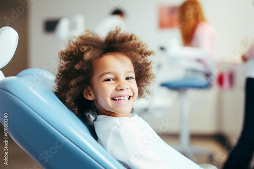 Happy little patient in dental chair waiting to be checked by a dentist. Healthy white teeth and perfect smile, healthcare.
